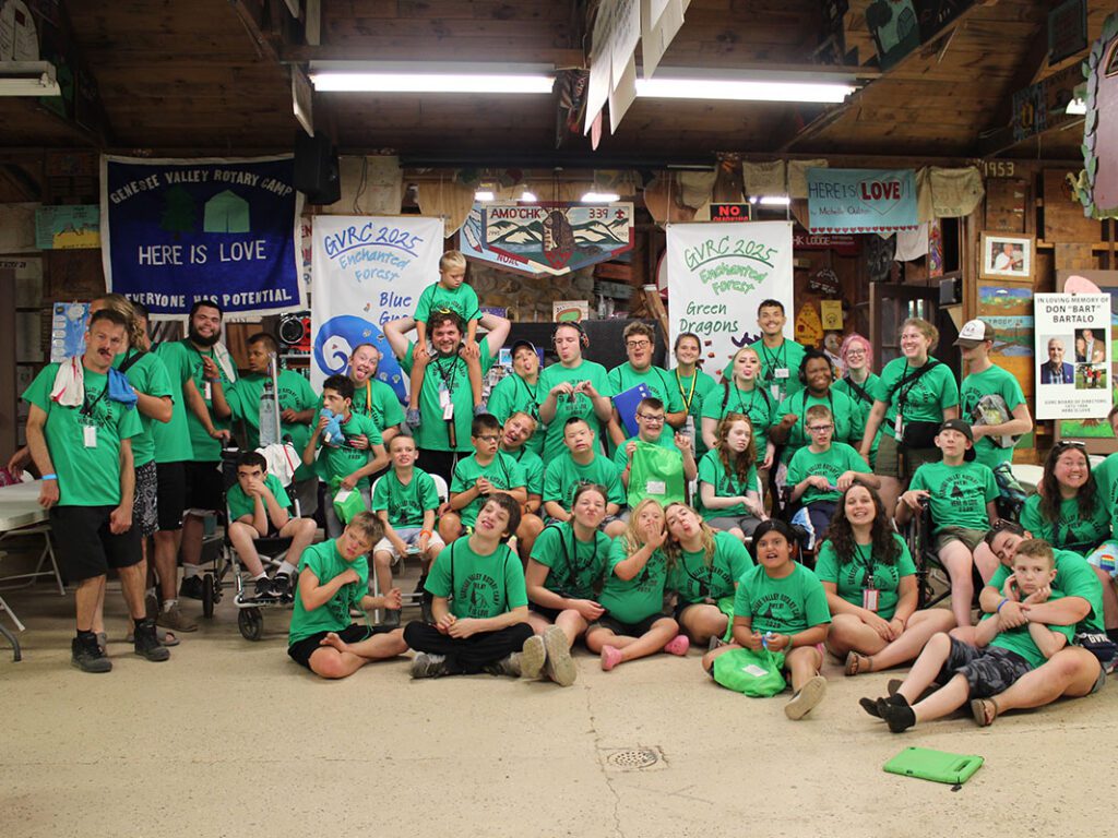 Group photo of people in green shirts smiling.