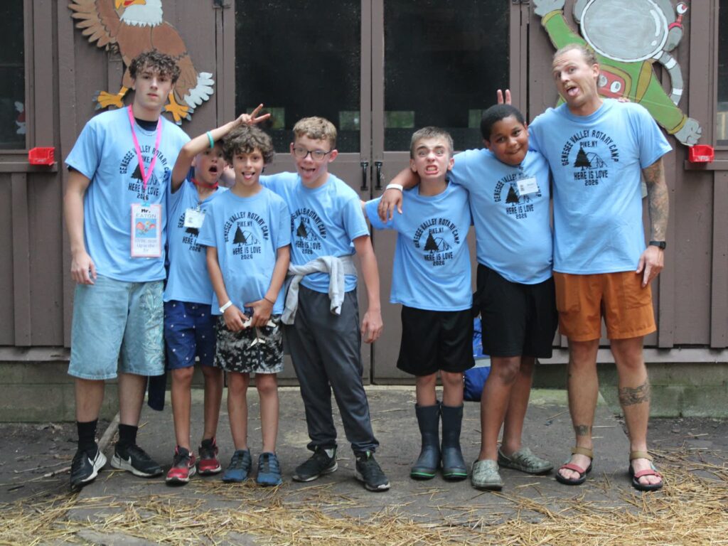 Campers and counselor wearing matching blue Rotary Camp shirts